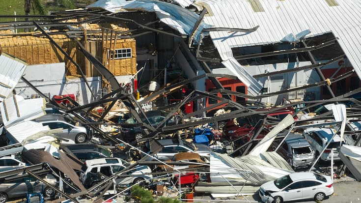 Hurricane Ian destroyed industrial building with damaged cars un