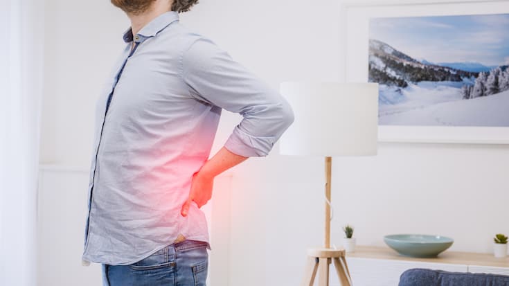Junger Mann Rückenschmerzen - Absenzenmanagement - Gesundheit
