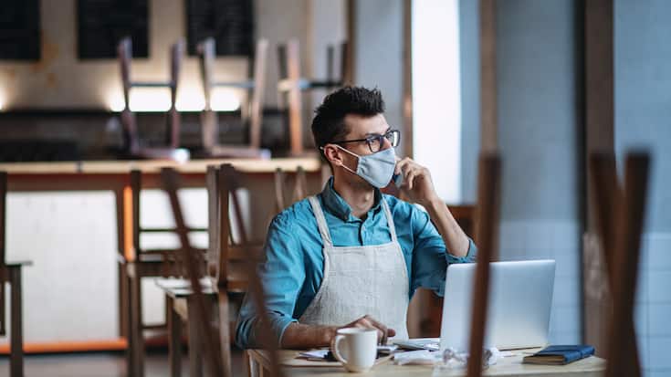 Frustrated owner sitting at table in closed cafe, small business
