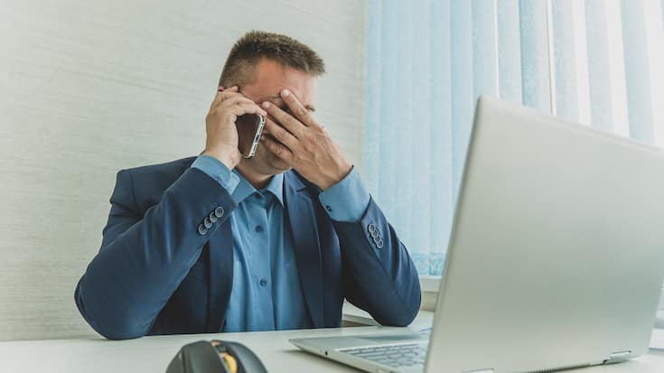 a tired employee at work in front of a computer monitor. Thought