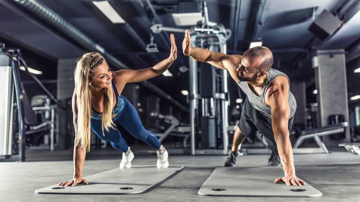Sport couple doing plank exercise workout in fitness centrum. Ma