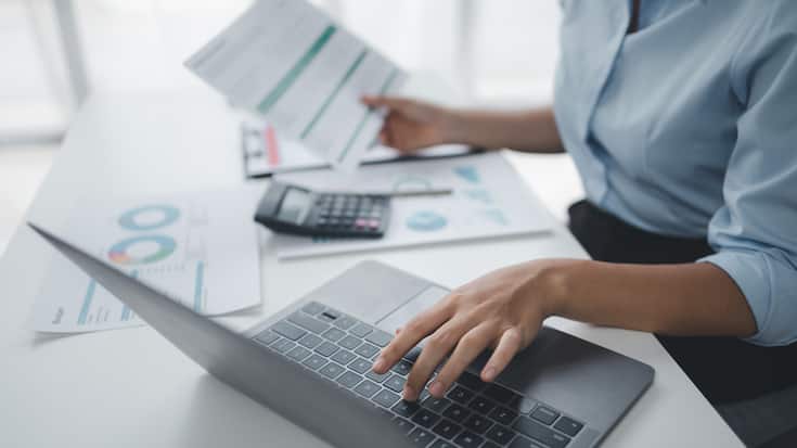 Business Frau mit Taschenrechner und Laptop