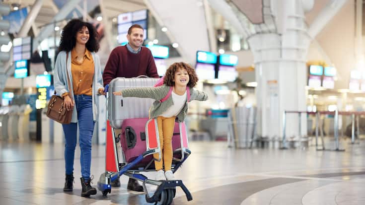 Airport, family and child excited for flight with suitcase troll