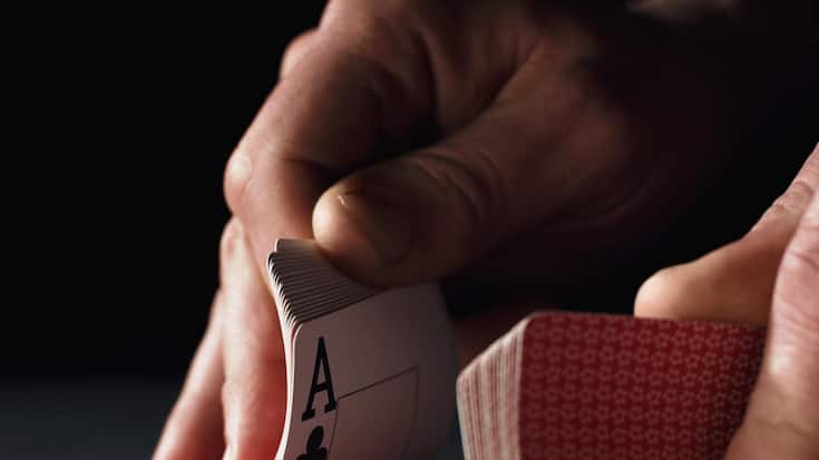Man shuffling playing cards, close-up