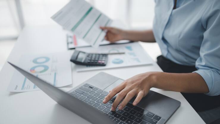 Business Frau mit Taschenrechner und Laptop
