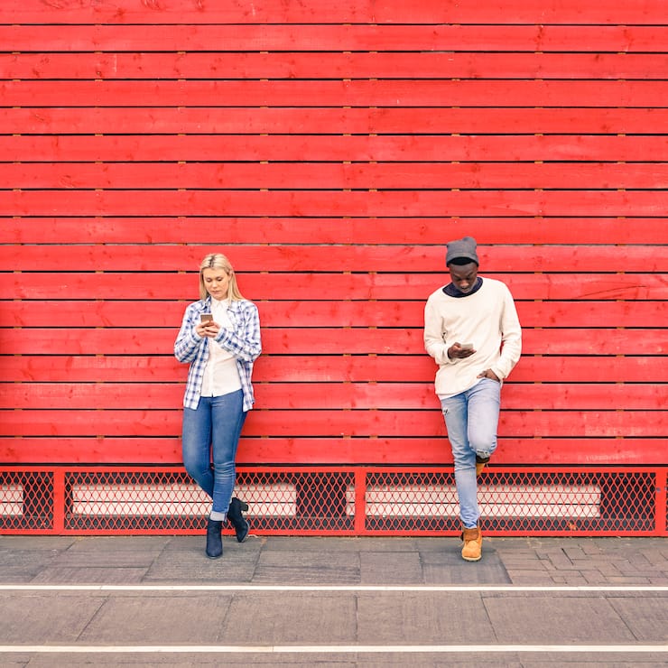 515792720 iStock Menschen mit Handy vor roter Wand