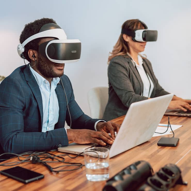 Metaverse, Mann und Frau mit VR Headset am Laptop in einem Büro