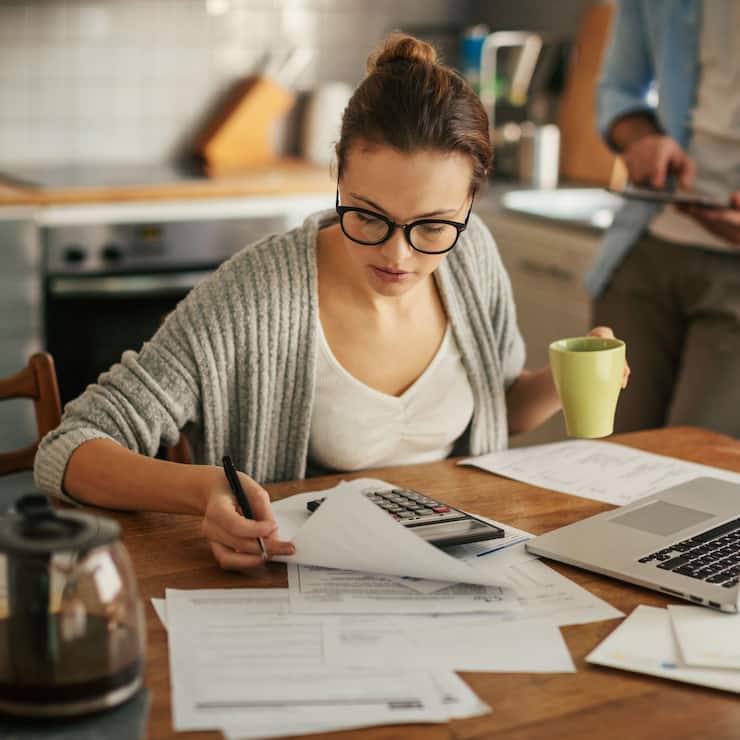 Junge Frau mit Taschenrechner und Laptop
