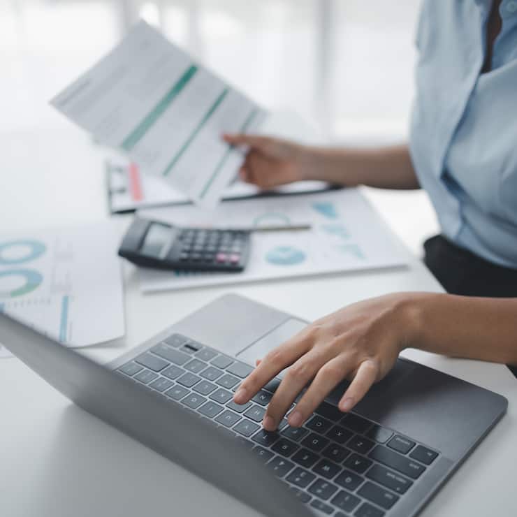 Business Frau mit Taschenrechner und Laptop