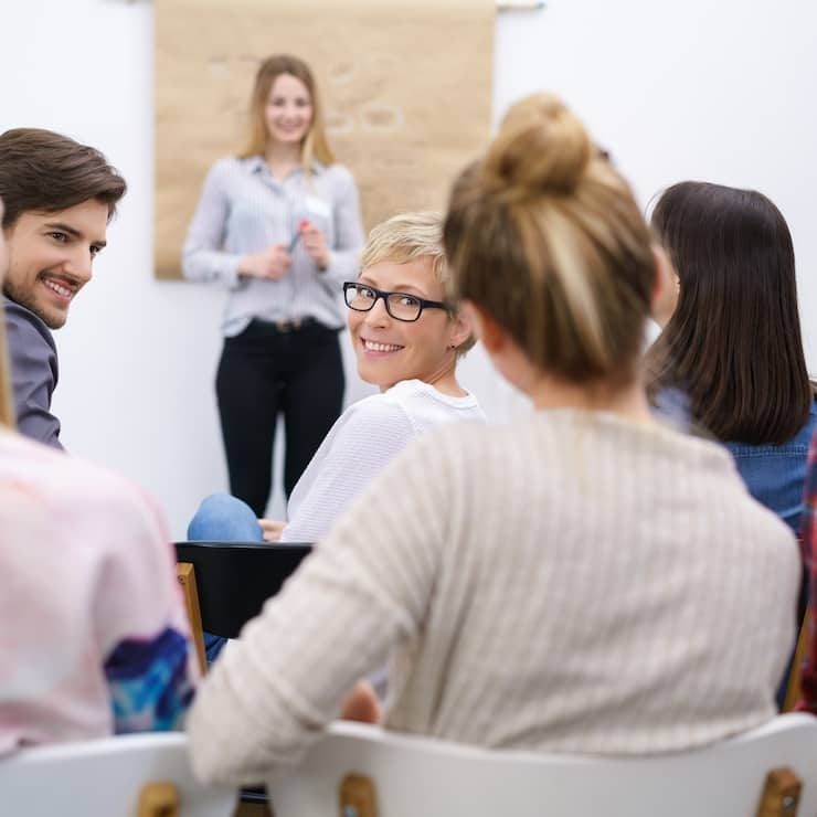 teilnehmer in einem vortrag schauen lA$?chelnd A 1/4ber die schulter zurA 1/4ck