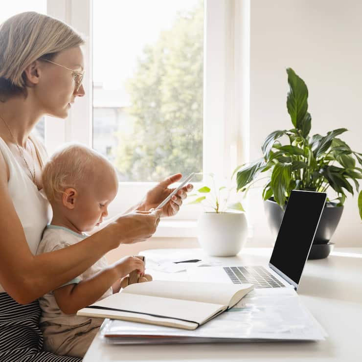 Freelancer mother using smart phone with baby son at desk model released, Symbolfoto property released, NDEF01801