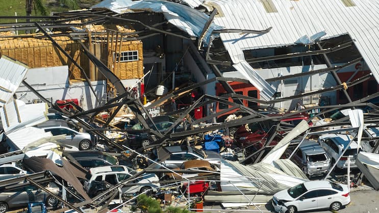 Hurricane Ian destroyed industrial building with damaged cars un