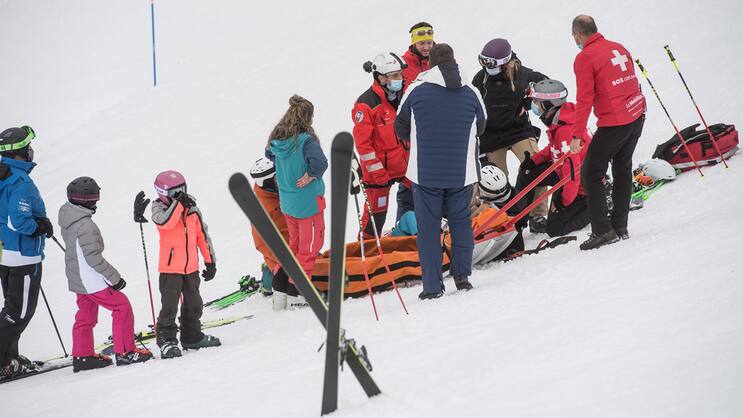 Sauvetage d'un skieur blessé par les médecins de la REGA, qui est transporté à l'hôpital par hélicoptère.