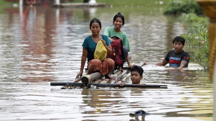 Des victimes d'inondations pataugent dans les eaux avec un radeau de fortune lors des inondations à Taungoo, division de Bago, Myanmar, en septembre 2024. Les fortes pluies déclenchées par le typhon Yagi ont provoqué de graves inondations dans certaines régions du Myanmar.