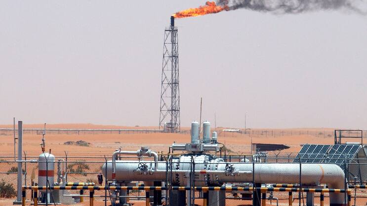 Blick auf eine Gasflamme hinter einer Pipelines in der Wüste beim Khurais Ölfeld, ungefähr 160 km von Riad, Saudi Arabien, entfernt.