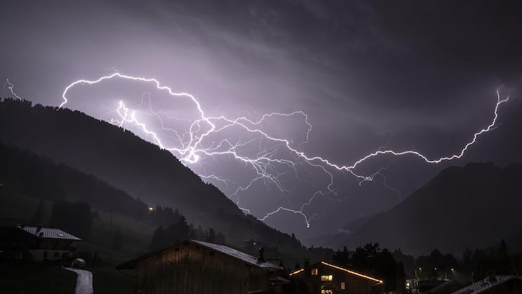 Ein verzweigter Blitz durchschneidet den Gewitterhimmel über dem Tal in Richtung Gsteig, aufgenommen Mitte Juli 2026 bei  Gstaad (BE).
